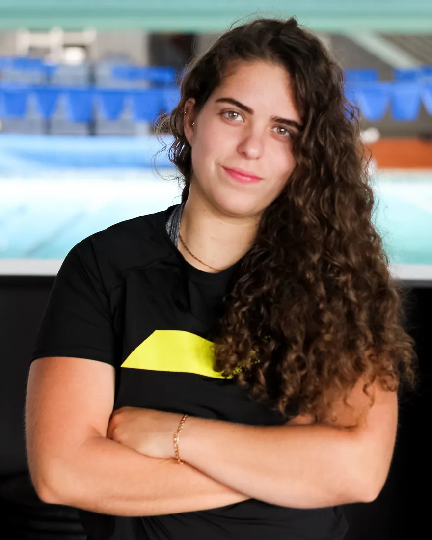 Raissa Nayra, personal trainer, de braços cruzados na academia